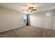 Carpeted bedroom boasts a ceiling fan, neutral walls, and natural lighting at 15844 W Lisbon Ln, Surprise, AZ 85379
