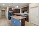 Kitchen showcasing island with granite countertop, dark wood cabinets, and stainless steel appliances at 15844 W Lisbon Ln, Surprise, AZ 85379