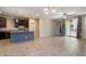 Open-concept living space featuring tile floor, kitchen island, and sliding glass doors to patio at 15844 W Lisbon Ln, Surprise, AZ 85379