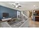 Staged living room showing an open concept layout with stairs, kitchen island, couch, and decor elements at 15844 W Lisbon Ln, Surprise, AZ 85379