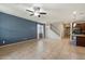 Expansive living room featuring tile floors and a ceiling fan, adjacent to the stairs leading to the second floor at 15844 W Lisbon Ln, Surprise, AZ 85379