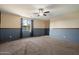 Spacious living room featuring plush carpeting, modern ceiling fan and large windows for ample natural light at 15844 W Lisbon Ln, Surprise, AZ 85379