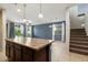 Open-concept kitchen and living room with island and staircase at 15844 W Lisbon Ln, Surprise, AZ 85379