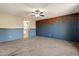 Stylish main bedroom with a blue accent wall, ceiling fan, and carpeted floor at 15844 W Lisbon Ln, Surprise, AZ 85379