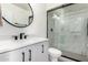 Sleek bathroom featuring a frameless glass shower, modern vanity with black hardware, and a round mirror at 1743 W Acoma Dr, Phoenix, AZ 85023