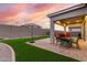 Backyard features a covered patio with an outdoor table and artificial turf at 17721 W Sandalwood Dr, Goodyear, AZ 85338