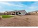 Wide backyard view including a covered patio, artificial grass, and desert landscaping at 17721 W Sandalwood Dr, Goodyear, AZ 85338