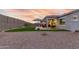 Wide backyard with a covered patio, seating, xeriscape, and artificial grass at 17721 W Sandalwood Dr, Goodyear, AZ 85338