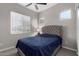 Comfortable bedroom with a ceiling fan, plush carpeting, and natural light from a window for a cozy retreat at 17721 W Sandalwood Dr, Goodyear, AZ 85338