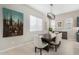 Bright dining room with a modern light fixture, neutral walls, and a dark wood table with seating for six at 17721 W Sandalwood Dr, Goodyear, AZ 85338