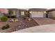 Charming single-story home featuring desert landscaping and a paved driveway leading to an attached two-car garage at 17721 W Sandalwood Dr, Goodyear, AZ 85338