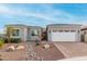Attractive home exterior with a brick driveway, a two-car garage, and low-maintenance desert landscaping at 17721 W Sandalwood Dr, Goodyear, AZ 85338