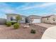 Well-kept home exterior with a two-car garage, brick driveway, and desert landscaping for easy maintenance at 17721 W Sandalwood Dr, Goodyear, AZ 85338