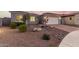 Charming home exterior with desert landscaping, stone accents, and a brick driveway leading to the garage at 17721 W Sandalwood Dr, Goodyear, AZ 85338