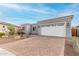 Home exterior featuring a spacious garage, paved driveway, and xeriscaping for water conservation and low maintenance at 17721 W Sandalwood Dr, Goodyear, AZ 85338