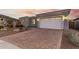 Spacious two-car garage with a brick paver driveway and well-manicured landscaping in the front yard at 17721 W Sandalwood Dr, Goodyear, AZ 85338