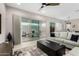 Bright living room boasts an expansive sliding glass door, chic furniture, and a ceiling fan at 17721 W Sandalwood Dr, Goodyear, AZ 85338