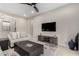 Spacious living room includes a stylish entertainment area, ceiling fan, and cozy sofa at 17721 W Sandalwood Dr, Goodyear, AZ 85338