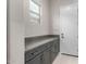 Well-organized mudroom area featuring custom cabinets and granite countertops with convenient access to the outdoors at 17721 W Sandalwood Dr, Goodyear, AZ 85338