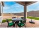 Covered patio with a black metal table and green cushioned chairs at 17721 W Sandalwood Dr, Goodyear, AZ 85338