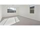 Sunlit bedroom with carpet, neutral walls, and two windows at 19015 W Rose Ln, Waddell, AZ 85355