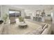 Open-concept living room with large windows, kitchen with island and dining area at 19015 W Rose Ln, Waddell, AZ 85355