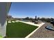 Backyard patio area with artificial grass, desert landscaping, and an inground pool at 19929 W Marshall Ave, Litchfield Park, AZ 85340