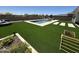 Backyard with artificial grass, inground pool, and a desert landscaped area at 19929 W Marshall Ave, Litchfield Park, AZ 85340