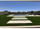 Landscaped backyard featuring an inground pool, artificial turf, and travertine stepping stones for easy maintenance at 19929 W Marshall Ave, Litchfield Park, AZ 85340