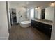 Bright bathroom featuring a soaking tub, glass shower, and a dual sink vanity with granite countertops at 19929 W Marshall Ave, Litchfield Park, AZ 85340