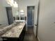 Bathroom featuring a spacious vanity with double sinks and a granite countertop, plus tile flooring at 19929 W Marshall Ave, Litchfield Park, AZ 85340