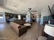 Spacious open-concept living area featuring wood-look tile, a large sectional sofa, and dark kitchen cabinetry at 19929 W Marshall Ave, Litchfield Park, AZ 85340