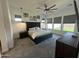 A spacious primary bedroom with a large bed, an elegant ceiling fan, and plentiful natural light from wide windows at 19929 W Marshall Ave, Litchfield Park, AZ 85340