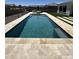 A luxurious rectangular pool with travertine tile surround and lounge seating offers a relaxing backyard oasis at 19929 W Marshall Ave, Litchfield Park, AZ 85340