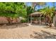 Backyard featuring lush trees and foliage with a gazebo, a grill, and a patio set for outdoor living at 20044 N 30Th Pl, Phoenix, AZ 85050