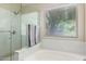 Bright bathroom featuring a soaking tub, a separate shower, and a large window at 20044 N 30Th Pl, Phoenix, AZ 85050
