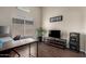 Office with hardwood floors, bright light from the window, a large TV, a desk, and a modern office chair at 20044 N 30Th Pl, Phoenix, AZ 85050