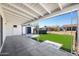 Covered back patio with pavers, artificial turf, and view of the storage shed and hot tub at 2204 E Birchwood Ave, Mesa, AZ 85204