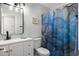 Bathroom featuring modern vanity, toilet and shower/tub combo with blue shower curtain at 2204 E Birchwood Ave, Mesa, AZ 85204
