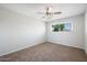 Neutral bedroom showcasing plush carpeting, window with blinds and a modern ceiling fan at 2204 E Birchwood Ave, Mesa, AZ 85204