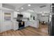 Updated kitchen with white cabinets and modern lighting, seamlessly connecting to a casual dining area for convenient entertaining at 2204 E Birchwood Ave, Mesa, AZ 85204