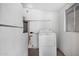 Functional laundry room features a washing machine and water heater against white walls at 2204 E Birchwood Ave, Mesa, AZ 85204