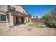 A manicured backyard featuring a covered patio, low-maintenance landscaping, and a partial grass area at 22706 N 17Th St, Phoenix, AZ 85024