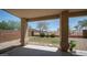 A covered patio showcasing a low-maintenance backyard featuring partial grass and desert landscaping at 22706 N 17Th St, Phoenix, AZ 85024