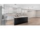 Spacious kitchen with white cabinets, stainless steel appliances, an island with a sink, and modern light fixture at 22706 N 17Th St, Phoenix, AZ 85024