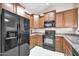 Modern kitchen with sleek black appliances, wooden cabinets, and ample counter space for meal preparation at 2727 N Price Rd # 6, Chandler, AZ 85224
