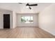 Bright, empty living room with hardwood floors, a large window, and a ceiling fan at 3021 W Angela Dr, Phoenix, AZ 85053