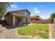 Lush backyard with a green lawn and a covered patio with a stone wall provides a serene outdoor space at 3376 E Lafayette Ave, Gilbert, AZ 85298