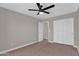 Neutral bedroom boasts carpet, a ceiling fan, closet, and an entrance to another room at 3376 E Lafayette Ave, Gilbert, AZ 85298