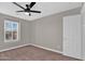 This bedroom has neutral carpet, a ceiling fan, view to the outside, and closet at 3376 E Lafayette Ave, Gilbert, AZ 85298